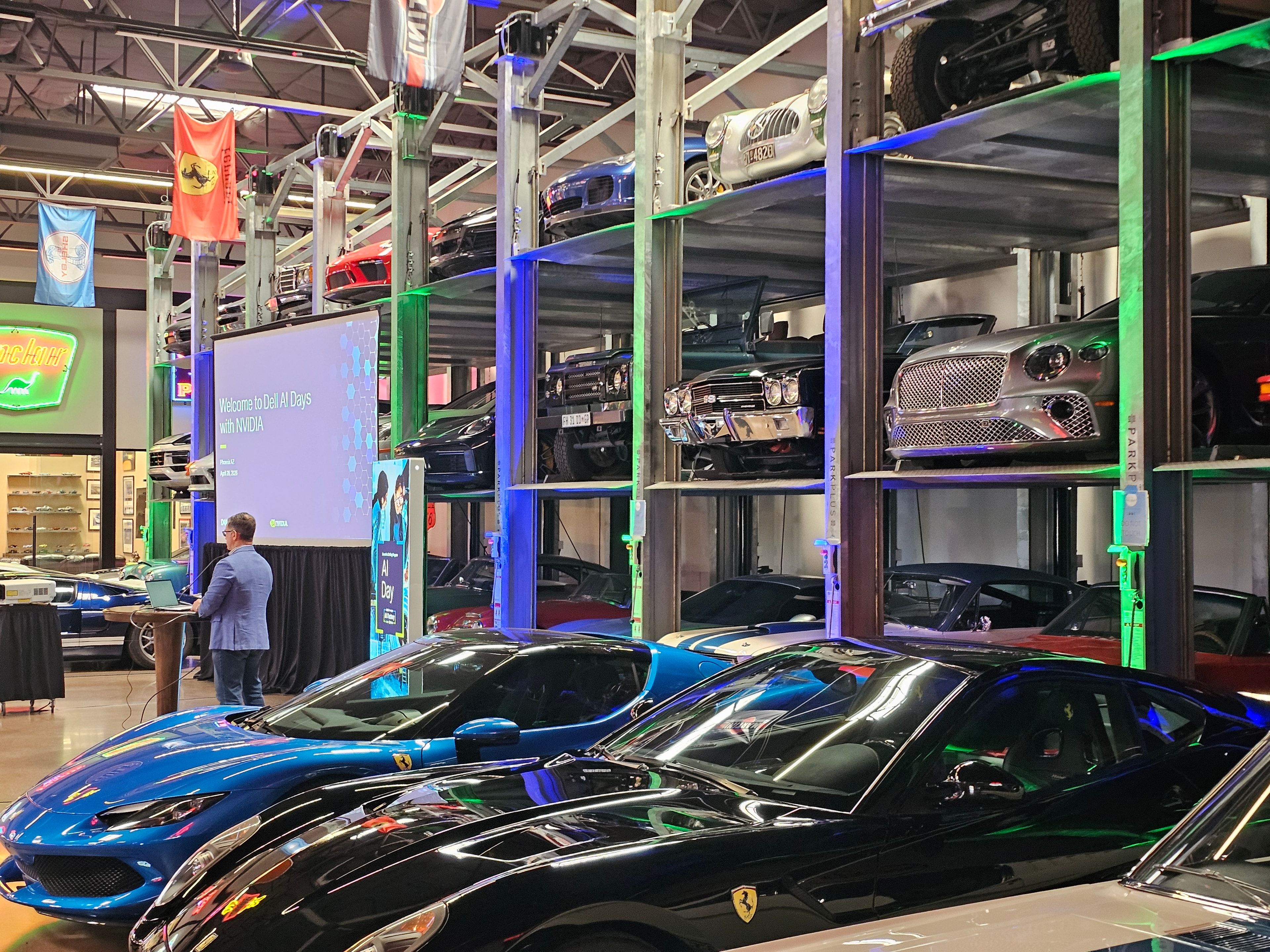 Indoor car show with luxury vehicles and display screens