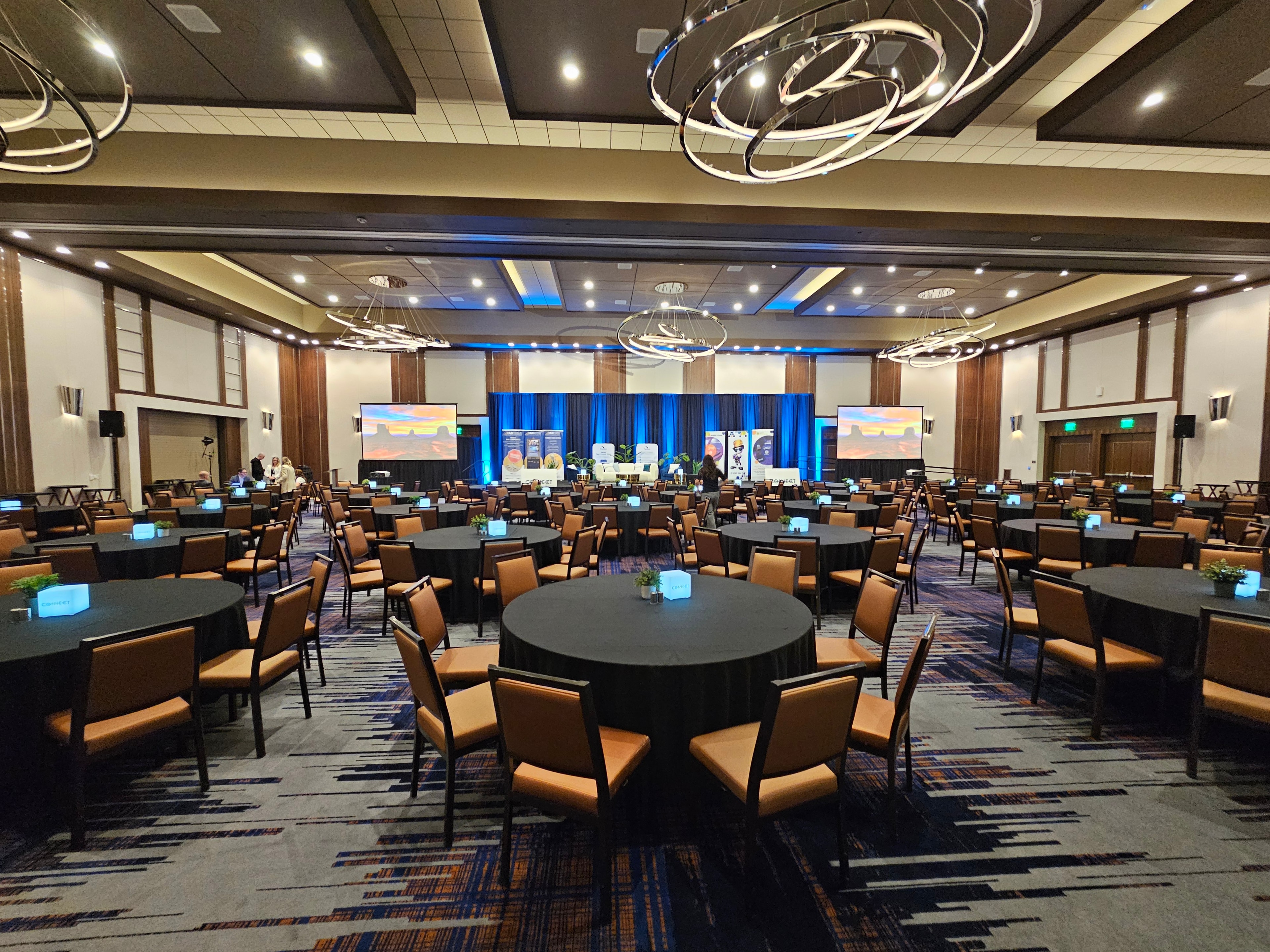 Modern conference ballroom with round tables and stage setup