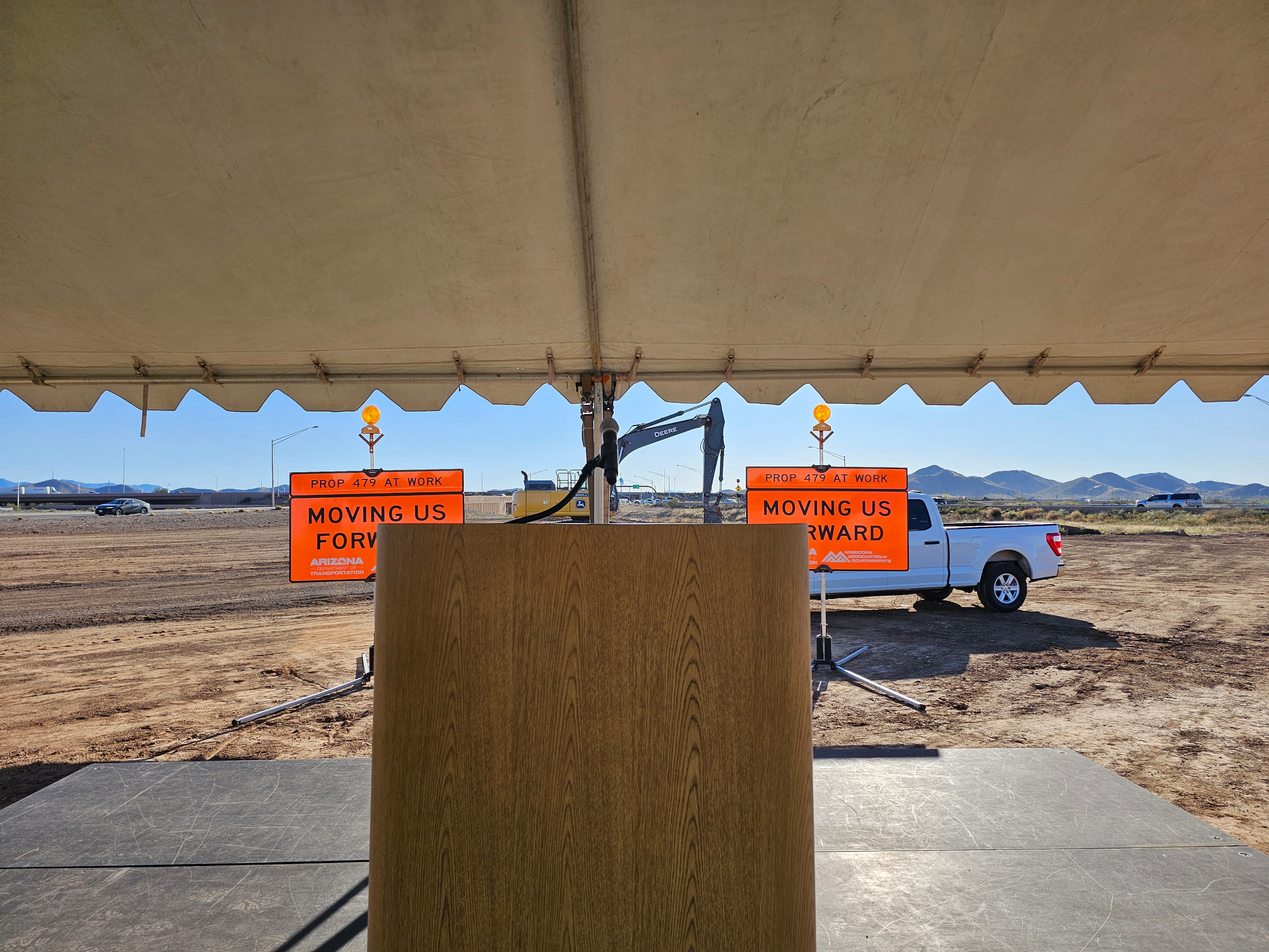 Construction site groundbreaking ceremony with Arizona signage