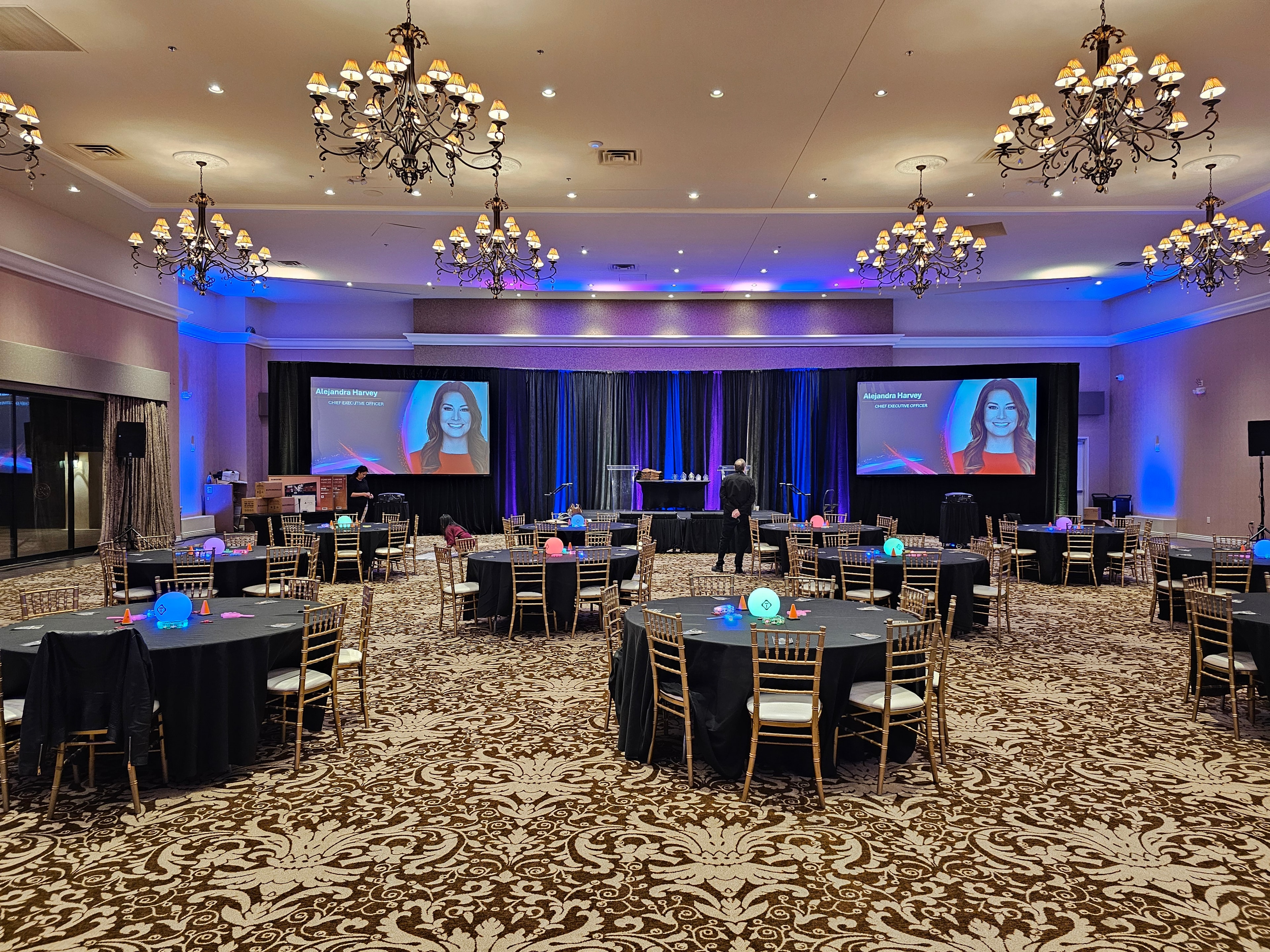Elegant ballroom event setup with blue uplighting
