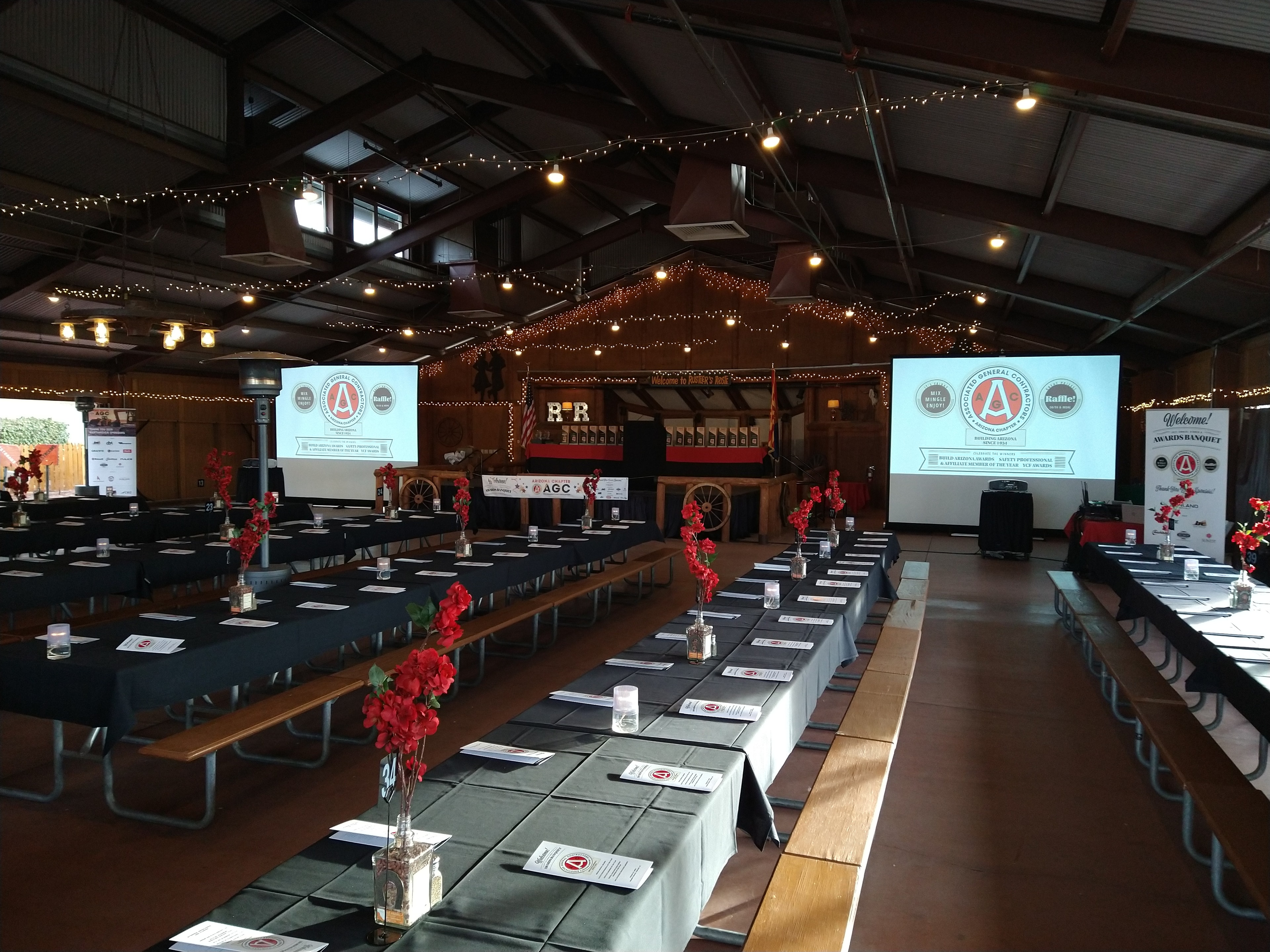 Event venue with string lights and red floral decor